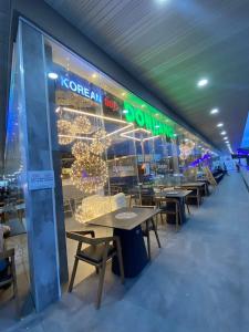 una tienda de comida coreana con mesas y luces en la ventana en Mactan Newtown Beach Condo, en Mactan