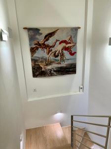 a painting hanging on a wall in a staircase at Areti 1 & Areti 2 in Kilada