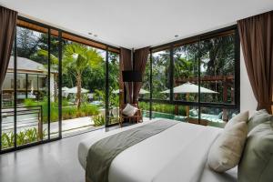 ein Schlafzimmer mit großem Bett und großen Fenstern in der Unterkunft Villa Dream Life by BaliSuperHost in Ubud