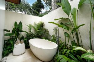ein Badezimmer mit Badewanne und Pflanzen in der Unterkunft Villa Dream Life by BaliSuperHost in Ubud + 14 Fotos