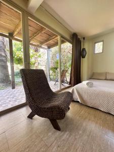sypialnia z krzesłem przed łóżkiem w obiekcie Punta Mango Surf Resort w mieście Jucuarán