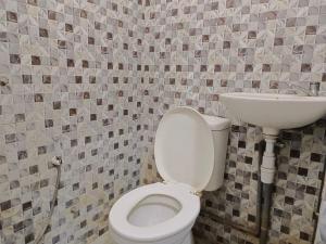 La salle de bains est pourvue de toilettes et d'un lavabo. dans l'établissement oemah jawa guesthouse jember, à Jember