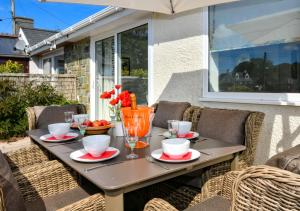 a table with plates and cups on a patio at Hillview in Llanbedrog