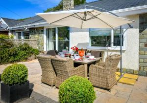 a table and chairs with an umbrella on a patio at Hillview in Llanbedrog