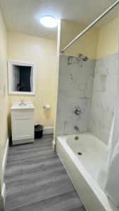 a bathroom with a white tub and a sink at Budget Inn Express in South Hill