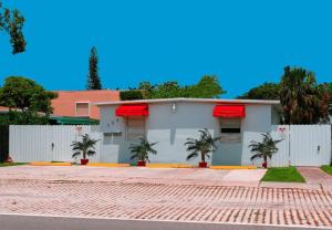 達尼亞灘的住宿－Flamingo Beach House，一座棕榈树掩映的白色房子