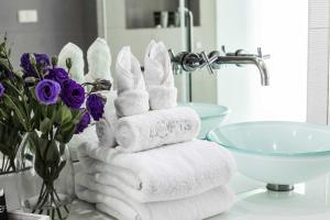 una pila de toallas en la encimera del baño con lavabo en BYD Lofts - Boutique Hotel & Serviced Apartments - Patong Beach, Phuket, en Patong Beach