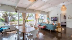 a living room with a table and a blue couch at Beachfront- The Art Cottage- Pet Friendly in Vincentia