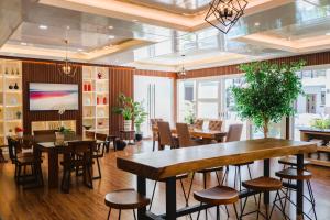 a dining room with tables and chairs and a tv at Teofely Gardens Resort near Tagaytay in Silang