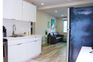 a kitchen with white cabinets and a black refrigerator at Flamingo Beach House in Dania Beach