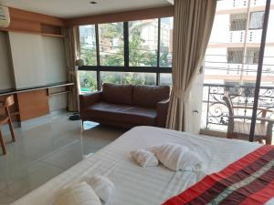 um quarto com uma cama, um sofá e uma janela em L18 residence แอลสิบแปด เรสซิเดนซ์ em Ban Zong Katiam