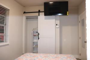 1 dormitorio con 1 cama y TV en la pared en Flamingo Beach House, en Dania Beach