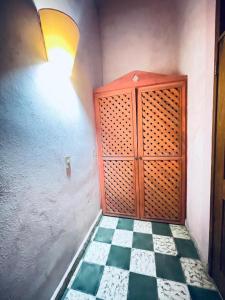 a room with a wooden cabinet and a checkered floor at Bless in Tela