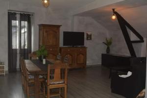 a living room with a dining table and a television at Gîte LORLAVIE in Arudy