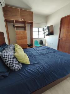 1 dormitorio con 1 cama azul y 2 almohadas en ¡Departamento a 5 minutos del Malecón! en Mazatlán
