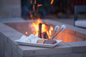 einen Teller mit Schokolade, Marshmallows und Löffeln in der Unterkunft Luxury Getaway: Hot Tub,Pool Table,Fire Pit in Palmdale