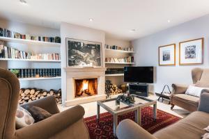 een woonkamer met een open haard en een televisie bij Hotel Costabella in Girona