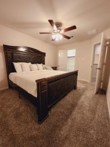 a bedroom with a large bed with a ceiling fan at Shella Home in Missouri City
