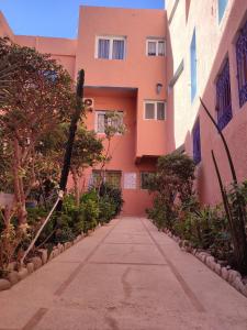 an empty sidewalk in front of a pink building at Private Room in Apartment TOV in Taghazout