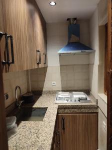 una piccola cucina con piano cottura e lavandino di Private Room in Apartment TOV a Taghazout