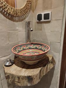 a bathroom with a large bowl sink on a wooden stump at Private Room in Apartment TOV in Taghazout