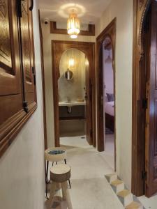 a hallway with a bathroom with a sink and a stool at Private Room in Apartment TOV in Taghazout