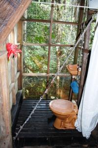 a bathroom with a toilet in front of a window at Reserva Natural Tanimboca in Leticia