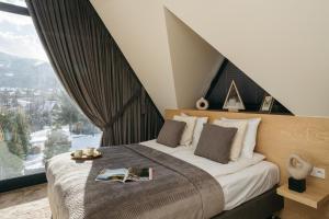 1 dormitorio con 1 cama y ventana grande en Skyline Villa by LoftAffair, en Kościelisko