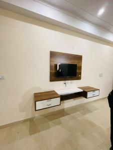 a living room with a tv on a wall at NIRMAL HOMES in Faridabad