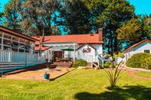 Casa blanca con techo rojo y patio en The Old Glenlyon School, en Glenlyon