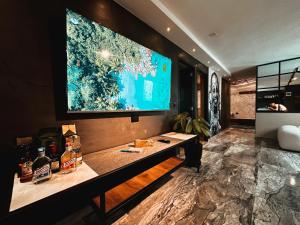 een kamer met een grote flatscreen-tv aan de muur bij LUXURY PALACE POBLADO MANILA in El Poblado