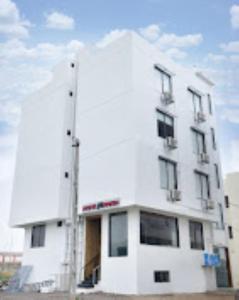 a large white building with aventh floor at Hotel Krish , Somnath in Somnath