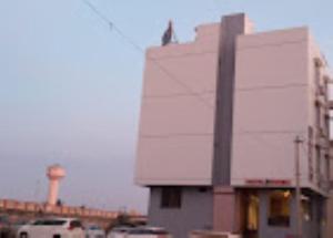 um edifício branco com um pássaro sentado em cima dele em Hotel Krish , Somnath em Somnath