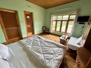 Un dormitorio con una cama grande y una ventana en Nilza Guest House, en Leh