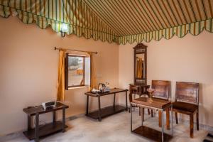 ein Zimmer mit 2 Tischen und Stühlen und einem Fenster in der Unterkunft Desert Vista Camp in Jaisalmer