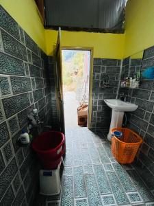 uma casa de banho com um WC vermelho e um lavatório. em Let’s Take it Easy (LTE) em Jibhi