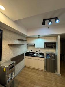 a kitchen with a refrigerator and a sink in it at Abreeza Place T2 - 720 in Davao City