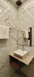 a bathroom with a sink and a marble wall at MD GRAND HOTEL & RESORT in Agra