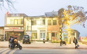 a man riding a motorcycle down a street in front of a building at MD GRAND HOTEL & RESORT in Agra