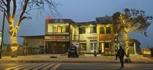 a person crossing a street in front of a building at MD GRAND HOTEL & RESORT in Agra