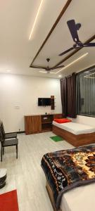 a bedroom with two beds and a flat screen tv at MD GRAND HOTEL & RESORT in Agra