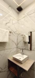 a bathroom with a sink and white marble walls at MD GRAND HOTEL & RESORT in Agra