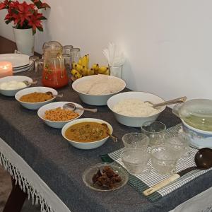 una mesa cubierta con tazones de comida y otros ingredientes en Forest edge villa, en Anuradhapura