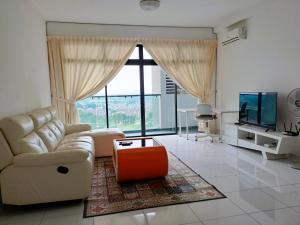 ein Wohnzimmer mit einem Sofa und einem TV in der Unterkunft JB Bukit Indah Skyloft Suites in Johor Bahru