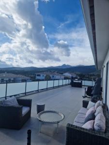 einen Balkon mit Sofas, einem Tisch und Aussicht in der Unterkunft VILLA entre mer, montagnes, étangs et rivières in Ventiseri