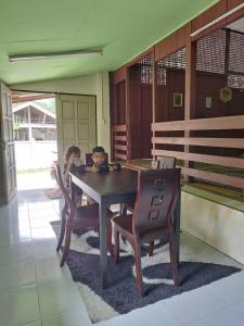 a child sitting at a table in a house at Rumah Kayu Aboh in Kuala Terengganu