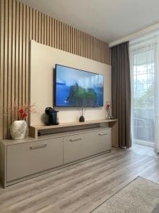 uma sala de estar com uma televisão de ecrã plano na parede em Alintoma Holiday apartment em Palanga