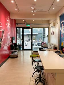 a restaurant with a bar with stools in a room at 打狗灣青年旅店 in Kaohsiung