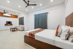 a bedroom with a bed and a living room at FabHotel Tree Suites in Bangalore