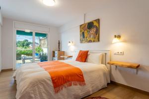 a bedroom with a bed with an orange and white blanket at Luxury Designer Beach Front Two Bedroom Apartment in Salou